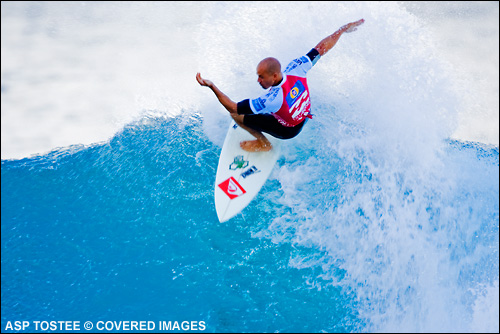 Eight times ASP world champion Kelly Slater eased his way into round four of the Billabong Pipeline Masters today. Slater scored several deep tube rides on the right handers at Backdoor along with some vertical re-entries to edge out Pipe specialist Mickey Bruneau. Surf Photo ASP Tostee