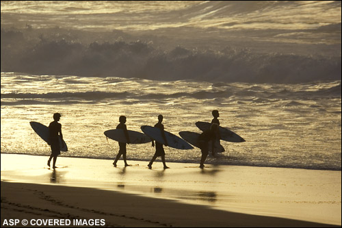 Surfers head out for a session at Pipe in the last hour of sunlight. Pic Credit ASP Tostee